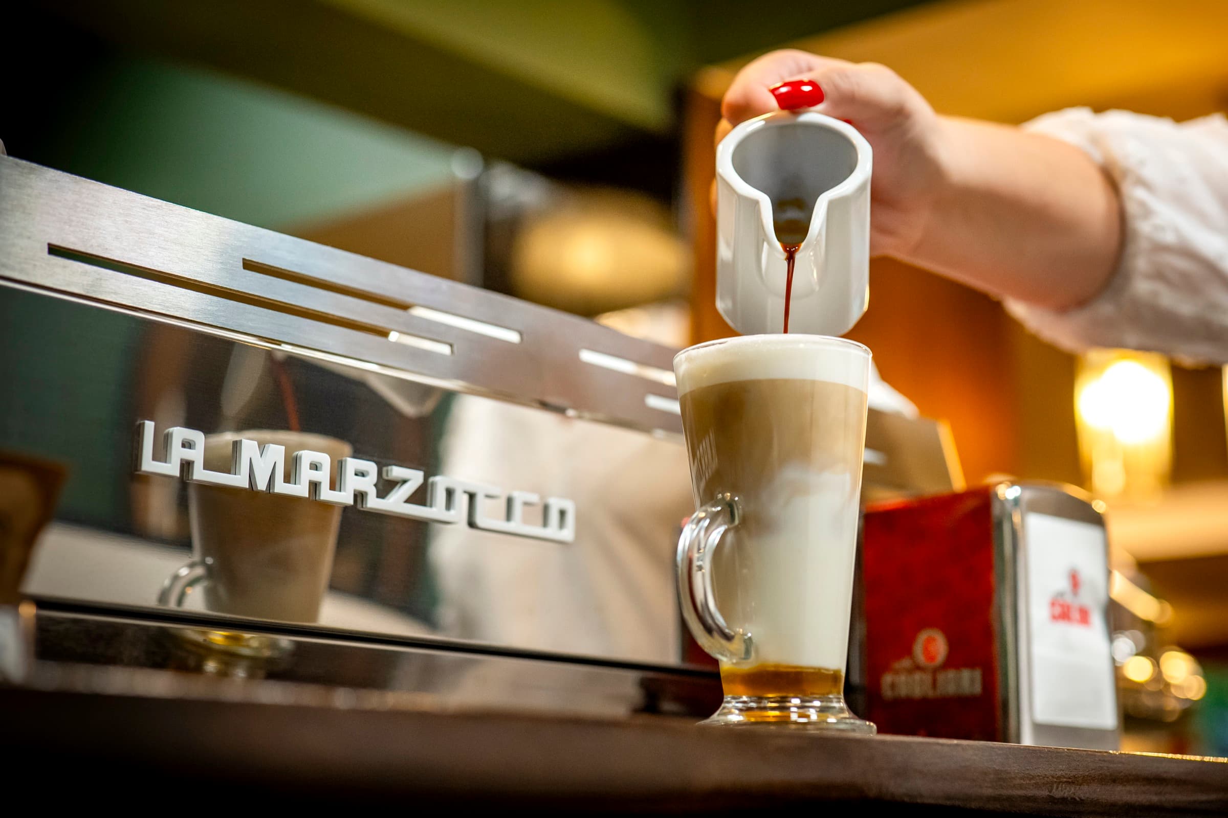 Frissen készülő latte macchiato a kávégépnél